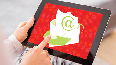 Close up of a mans hands holding a tablet with an envelope and a red background on the screen.