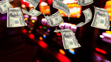 cash floating in air in front of slot machines
