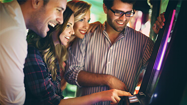 Group of friends gathered around the slot machines.