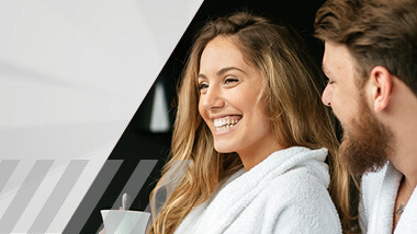 Woman and man in bathrobes laughing.