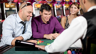 Men at a table game playing cards.