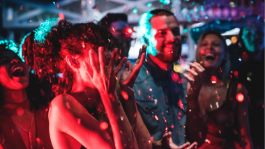 group of people dancing with confetti falling