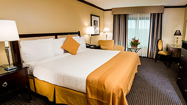 white and tan double bed in a hotel room