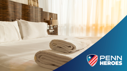 PENN Hero logo with towels on hotel bed